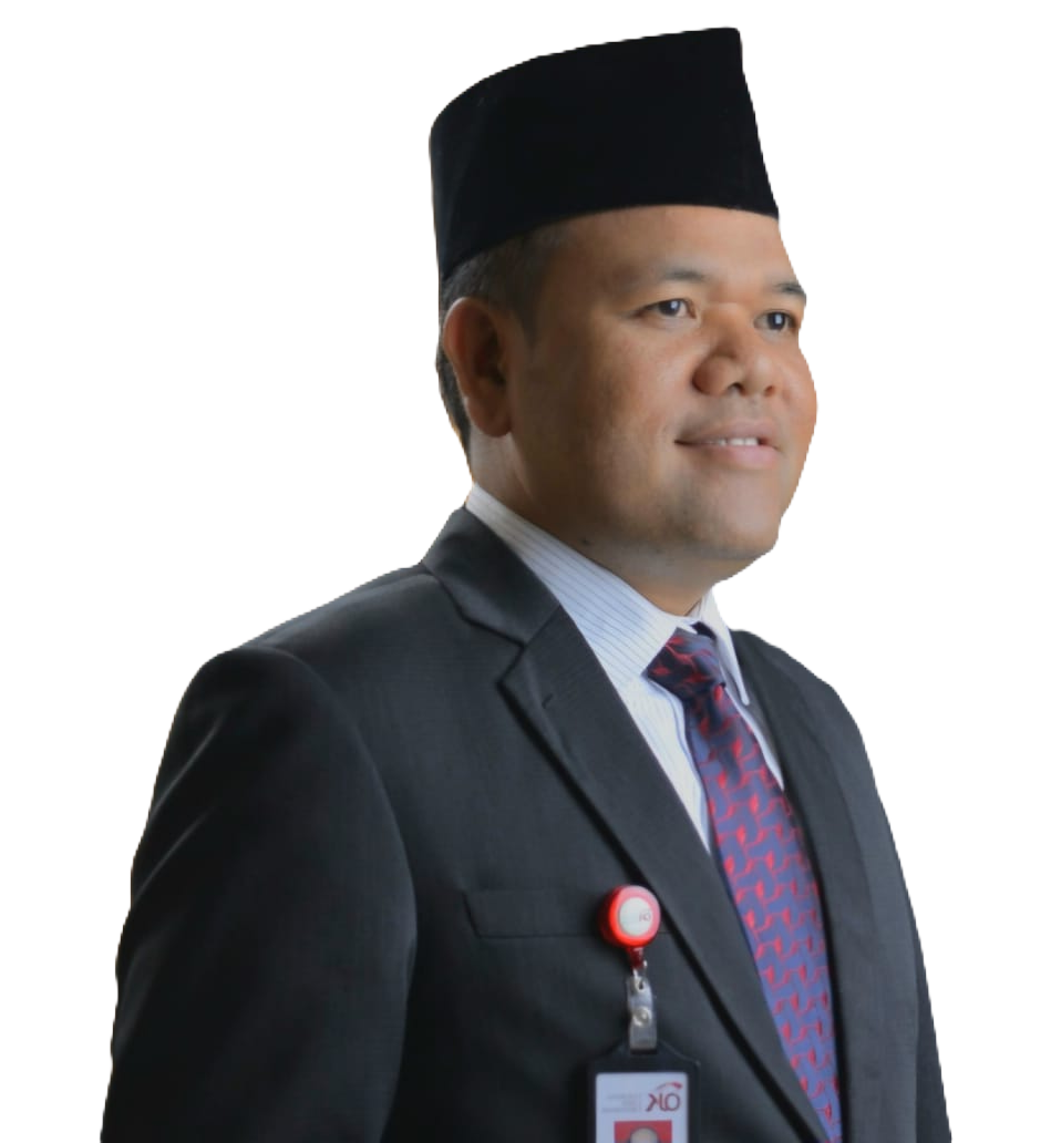 A man in a suit and traditional cap, smiling confidently, with an ID badge visible on his jacket.